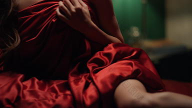 未知的女人覆盖红色的丝绸表卧室认不出来女孩放松床上