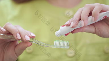 关闭女人手挤压牙膏牙刷口服卫生概念