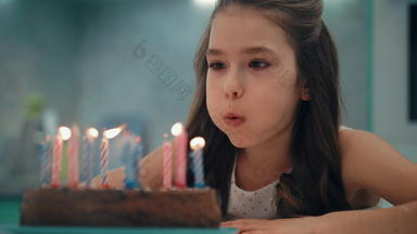 肖像女孩吹蜡烛慢运动孩子快乐生日概念