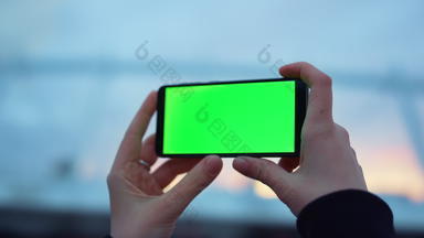 女人手智能手机绿色屏幕在户外夫人持有手机