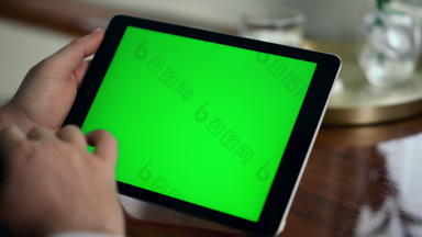成人手刷绿色平板电脑屏幕特写镜头男人。持有浓度关键电脑