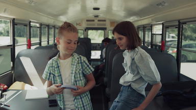 13岁以下的同学们玩会说话的学校公共汽车青少年孩子们等待骑首页