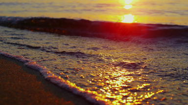 特写镜头海波打破晚上海滨慢运动阳光反映