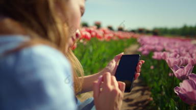回来视图年轻的女人触碰智能手机屏幕手指花场