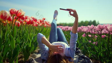 放松年轻的女人摆动腿蓝色的天空背景郁金香场
