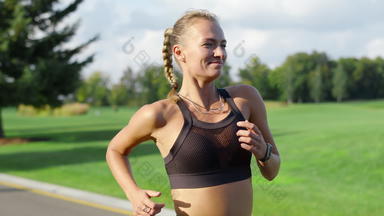 微笑女运动员慢跑绿色公园女人早....锻炼