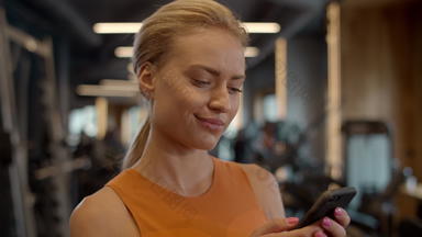 思考运动员女人智能手机健身房体育运动女孩发短信体育运动俱乐部