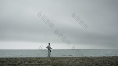 活跃的运动员练习武术艺术海滩男人。培训空手道