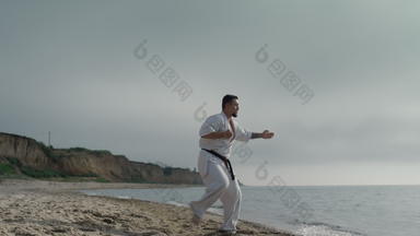 <strong>空手道</strong>运动员练习踢阳光明媚的海滩运动男人。<strong>培训</strong>武术艺术
