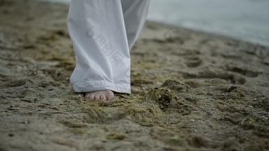 未知的光着脚男人。步进海滩特写镜头运动员锻炼海岸