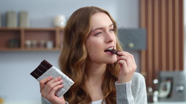 特写镜头年轻的女人吃巧克力厨房放松女孩享受巧克力