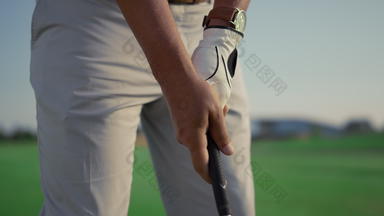 球员持有高尔夫球推杆俱乐部打高尔夫球游戏男人。玩体育运动活动