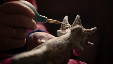 特写镜头女人手装修产品陶器陶艺家绘画玩具鹿