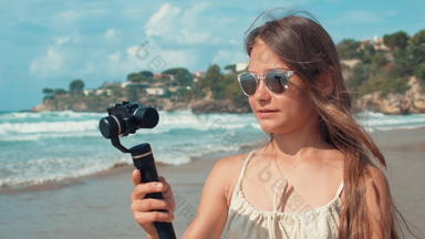年轻的女人记录<strong>视频户外</strong>快乐的<strong>视频</strong>博客女孩相机海滩