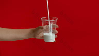宽视图女人手倒牛奶空塑料玻璃慢运动
