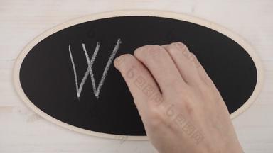 前视图平躺女人的手写作大写字母粉笔黑板上
