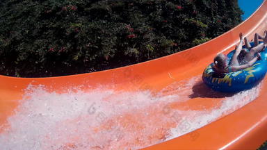 女孩滑动水幻灯片娱乐水上乐园夏天假期人有趣的骑幻灯片户外水公园假期