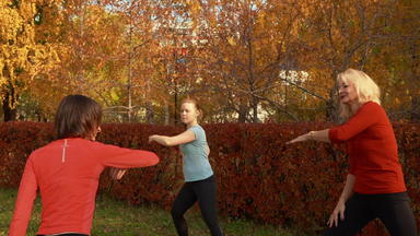 女性培训编排秋天公园背景适合女人练习瑜伽户外类秋天公园体育运动女人跳舞户外健身房