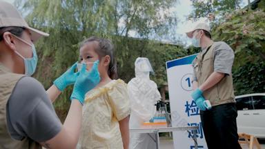 社区志愿者帮小女孩戴口罩保护高清视频