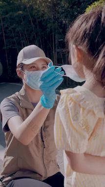 社区志愿者帮小女孩戴口罩疫情实拍素材