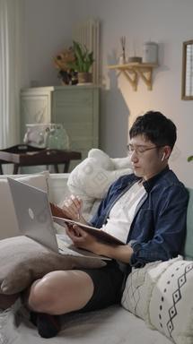 年轻人使用电脑起居室垂直构图舒服素材