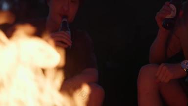 年轻人夜晚在篝火旁喝啤酒北京实拍
