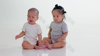 两个可爱宝宝坐在地上玩耍焦虑高清实拍