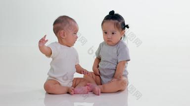 两个可爱宝宝坐在地上玩耍柔和清晰实拍