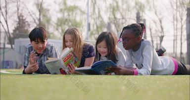 多种族儿童趴在草地上看书在校生学校画面