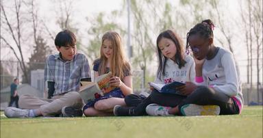 多种族儿童坐在草地上看书草地12岁到13岁<strong>视频</strong>素材