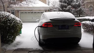 雪中的电动汽车充电电插头素材