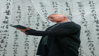 青年男人站在书法前汉字中摄像