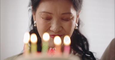 幸福的老年女人<strong>许愿</strong>吹蜡烛老年住宅房间宣传素材