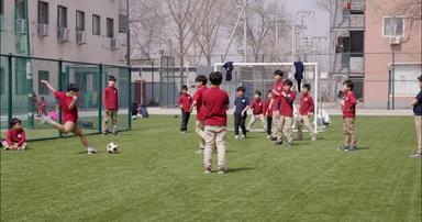 国际学校学生在踢足球童年协助视频