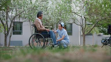 护士为坐轮椅的老人按摩老年