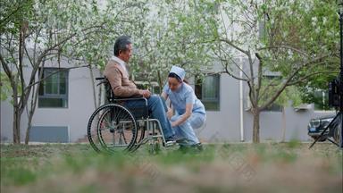 护士为坐轮椅的老人按摩治病医护服清晰实拍