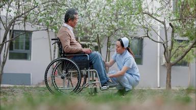 护士为坐轮椅的老人按摩老年视频素材