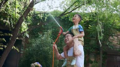 快乐父子在院子里浇水水枪溅场景拍摄