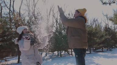 幸福情侣在雪地里玩耍高举手臂树林清晰视频