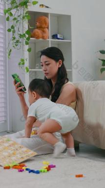 看手机的年轻妈妈英文字<strong>母婴儿</strong>期实拍素材