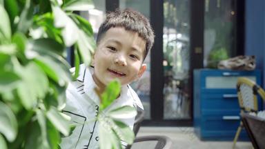 小男孩在树丛里玩捉迷藏环境保护休闲装视频