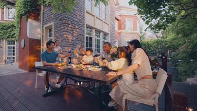 快乐大家庭在庭院里用餐中年端着镜头