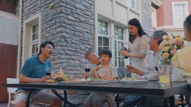 快乐大家庭在庭院里用餐高清实拍