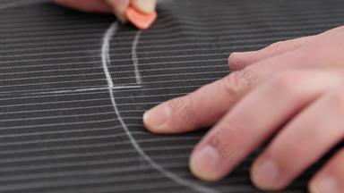 裁缝手工作缝纫模式讲习班男人。裁缝创建行工作粉笔个人桌子上发展中刺绣模式条纹黑色的织物