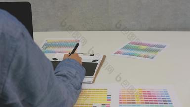 室内设计师画图形平板电脑办公室艺术家工作电脑选择颜色斯沃琪样本目录调色板指南工作场所摄影师修整照片设计创造力的想法概念