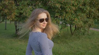 年轻的美丽的女人<strong>条纹衬衫</strong>太阳镜把扔长头发绿色公园超级慢运动