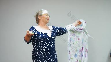 上了年纪的女人蓝色的衣服持有香水演讲香水