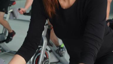 健身女人培训室内自行车骑自行车类集团体育运动人旋转自行车自行车健身房有氧运动培训重量损失概念