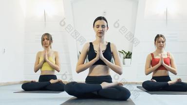 女孩练习瑜伽瑜伽教练学生冥想工作室相机移动