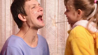 五年女儿玩医生爸爸看起来喉咙鼻子耳朵显示拇指爸爸健康的